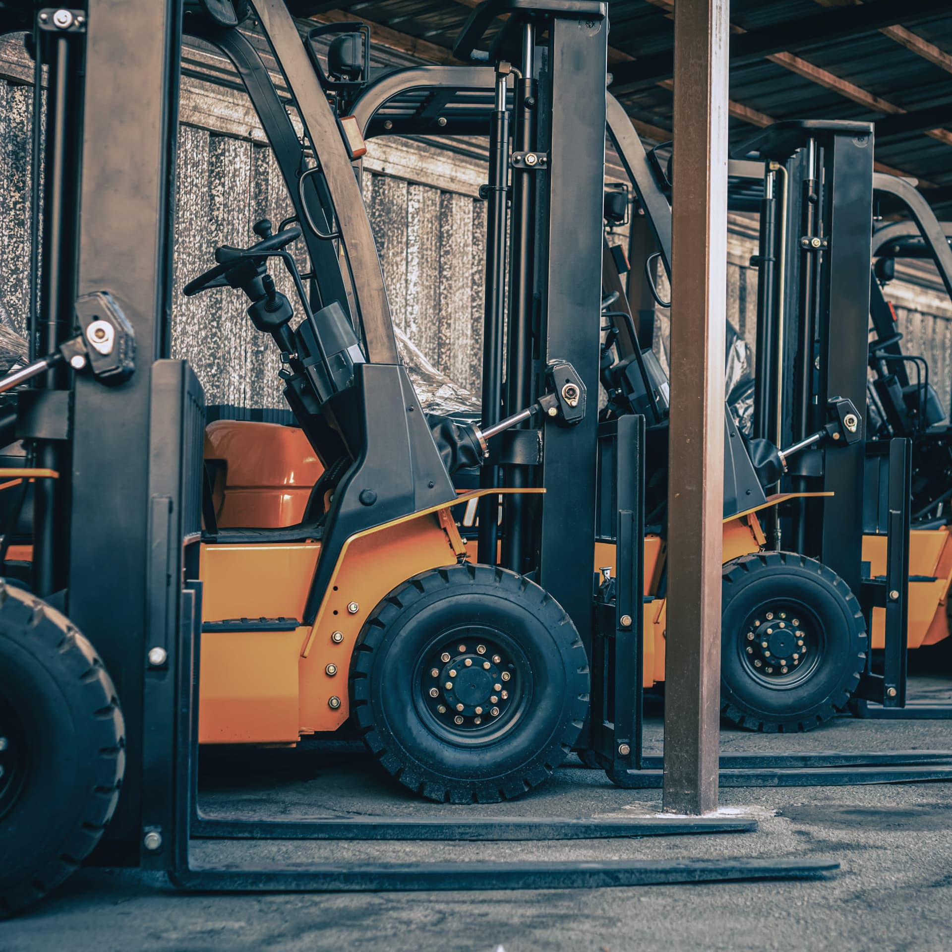 Oranje vorkheftrucks op een rij in een loods